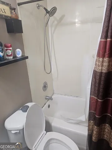 a bathroom with a toilet and a shower