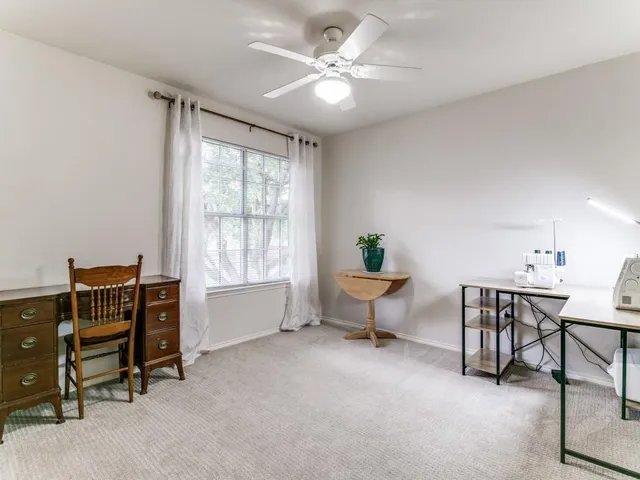 a living room with furniture and a ceiling fan