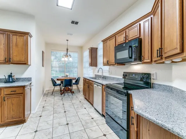 a kitchen with stainless steel appliances granite countertop a stove microwave and sink