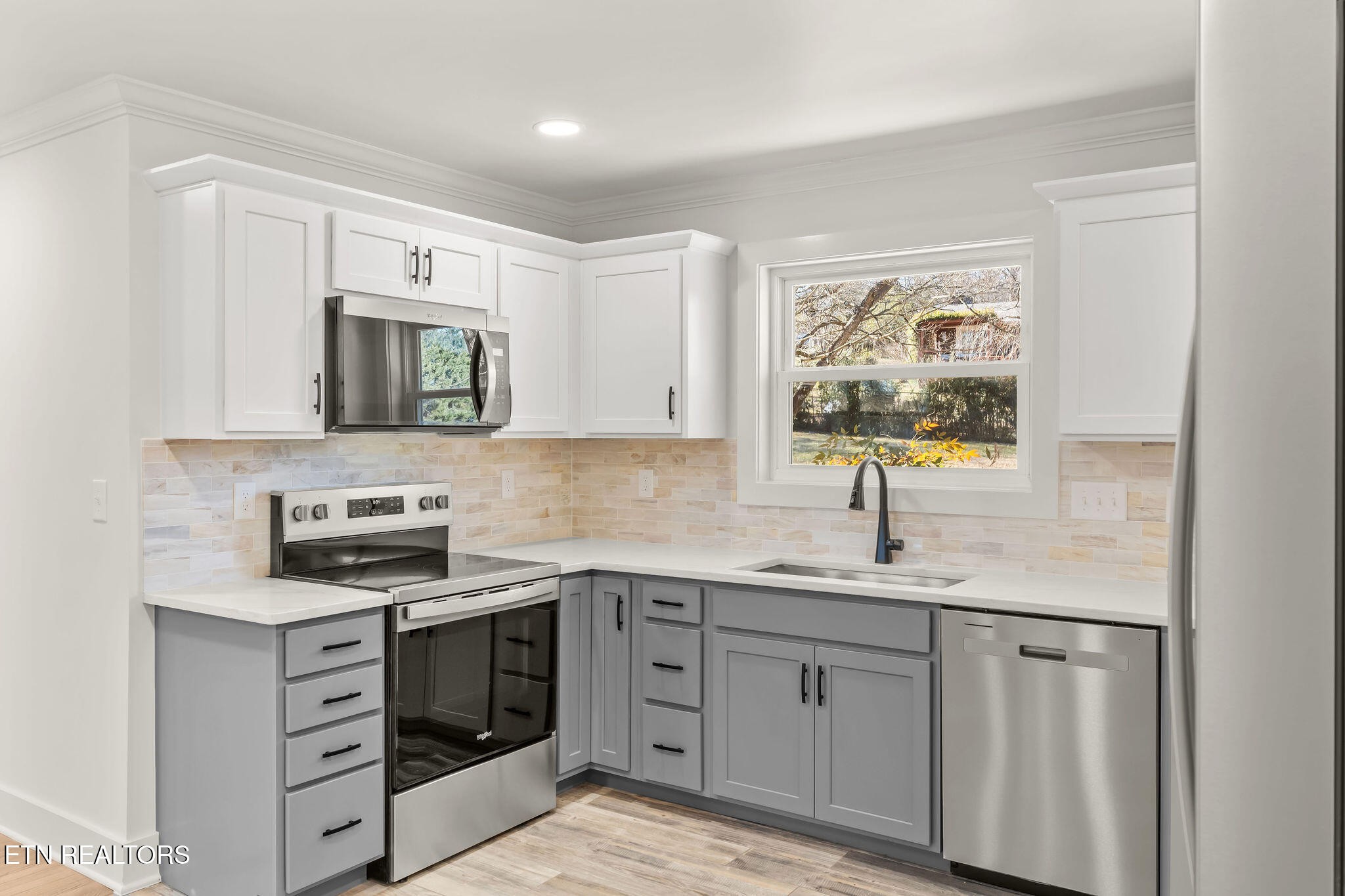 221 Medford Road Knoxville, TN 37922 - Photo 11 of 35 a kitchen with white cabinets stainless steel appliances and a sink
