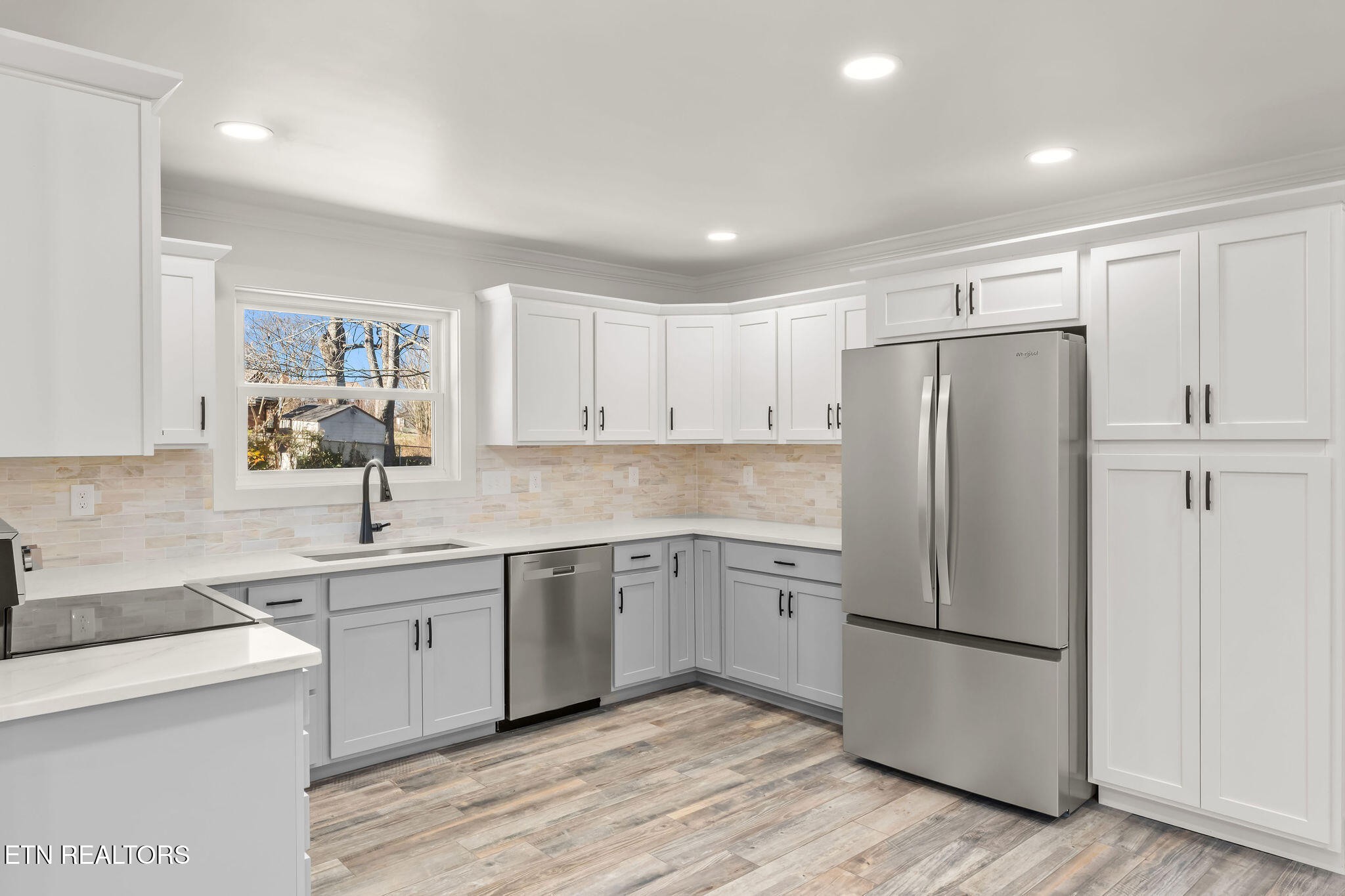 221 Medford Road Knoxville, TN 37922 - Photo 12 of 35 a kitchen with a sink a refrigerator a cabinets and wooden floor