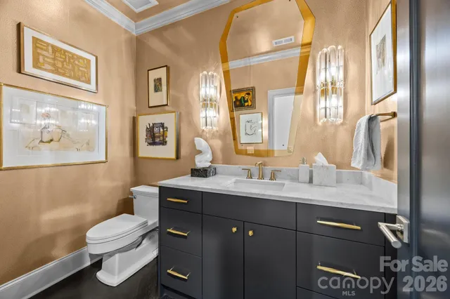 a bathroom with a granite countertop toilet sink and mirror