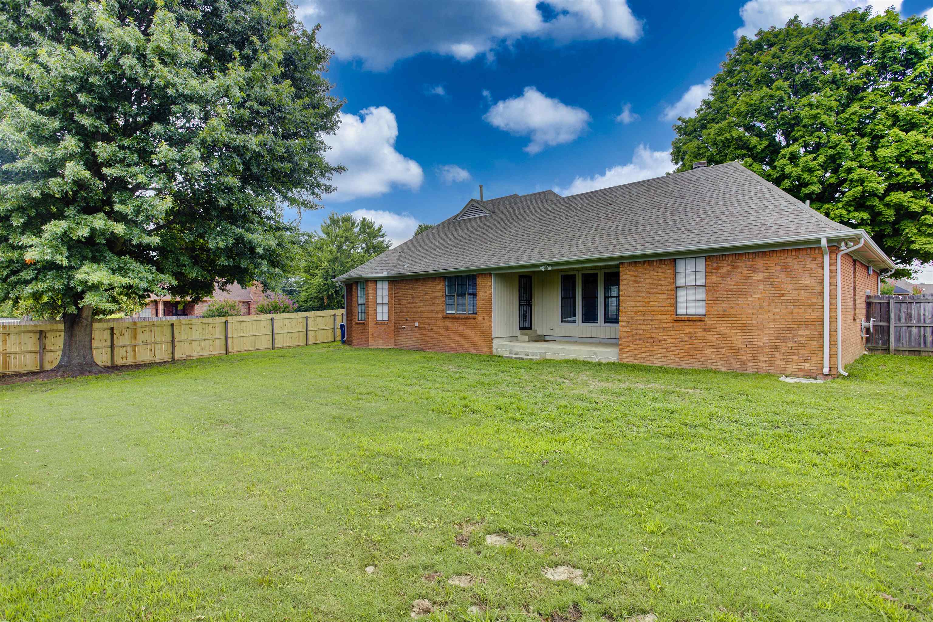 5259 Ross Road Memphis, TN 38141 - Photo 3 of 17 a backyard of a house with plants and large tree