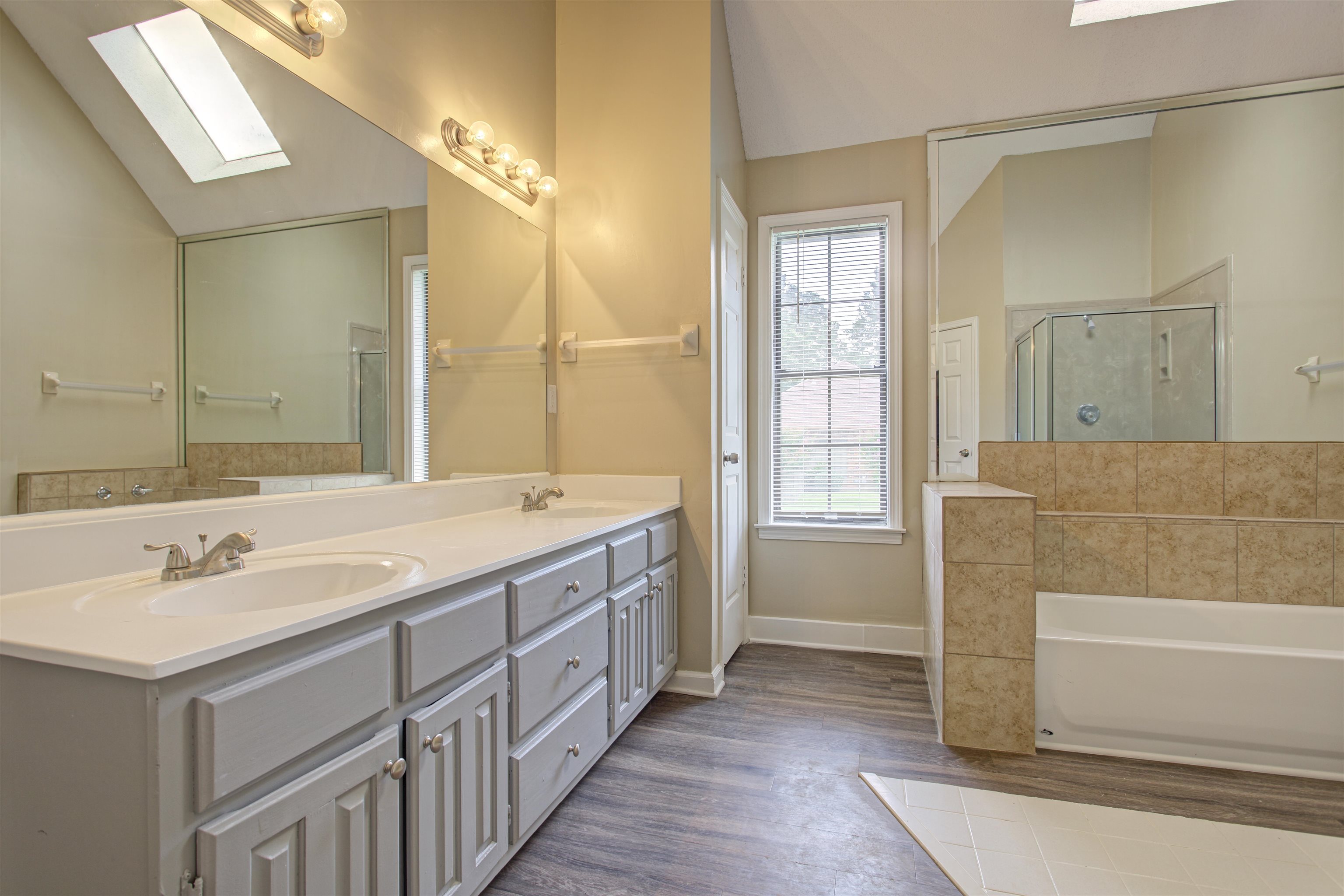 5259 Ross Road Memphis, TN 38141 - Photo 10 of 17 a bathroom with a double vanity sink a mirror and a bathtub