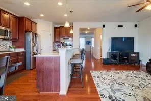a kitchen with stainless steel appliances kitchen island granite countertop a refrigerator and microwave