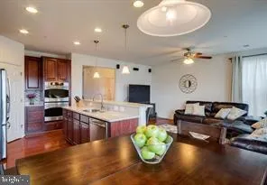 a living room with furniture kitchen view and a wooden floor