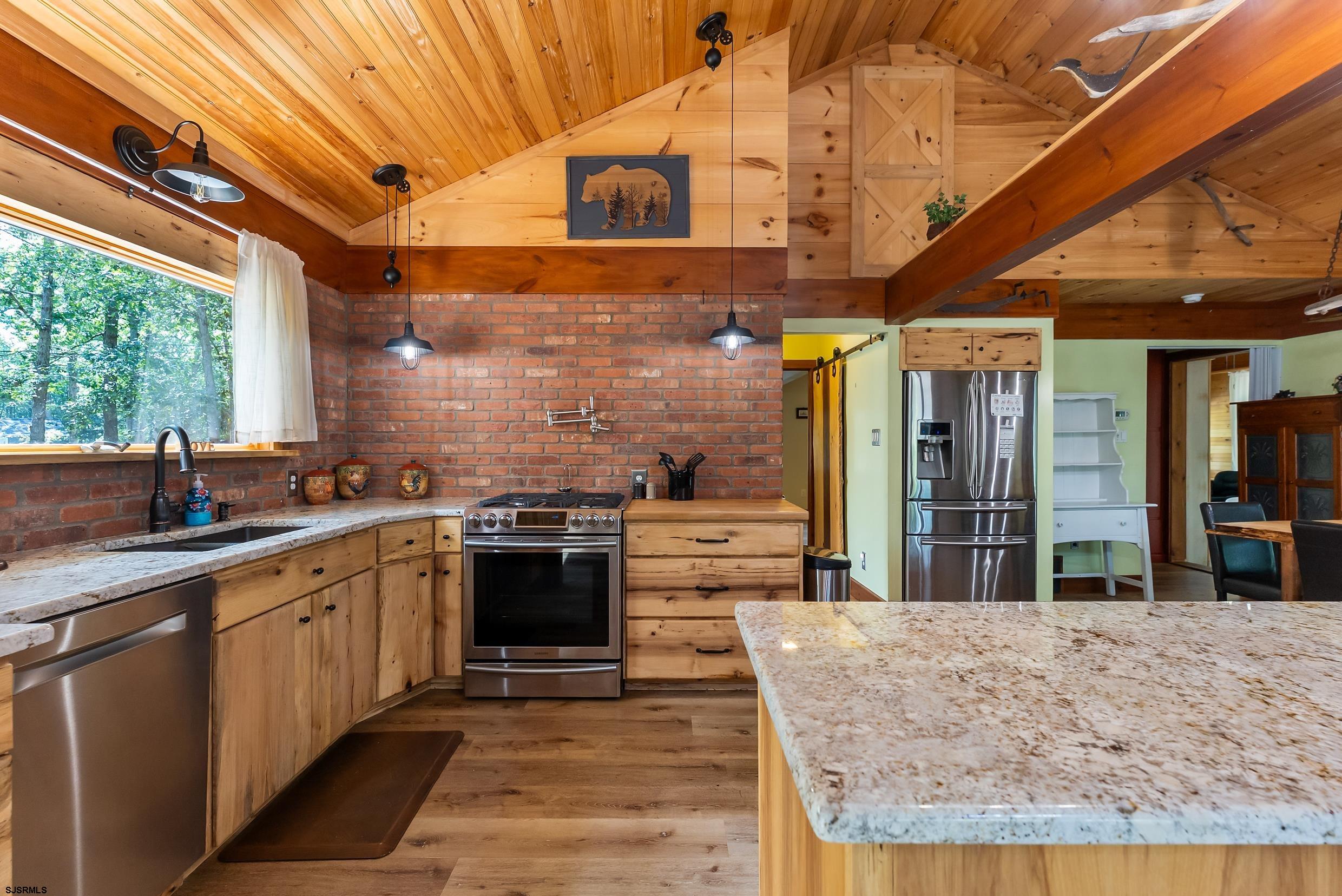 a kitchen with stainless steel appliances granite countertop a sink stove and cabinets