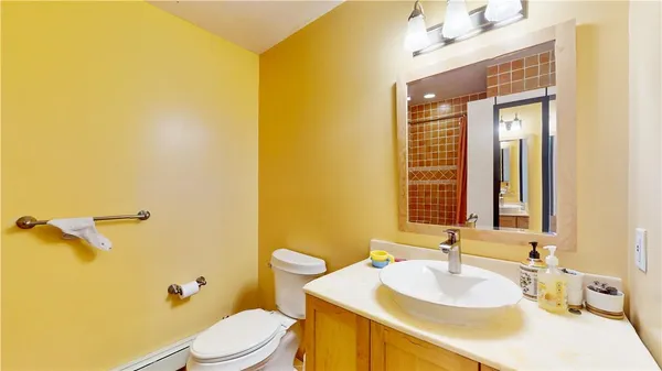 a bathroom with a granite countertop sink mirror vanity and toilet