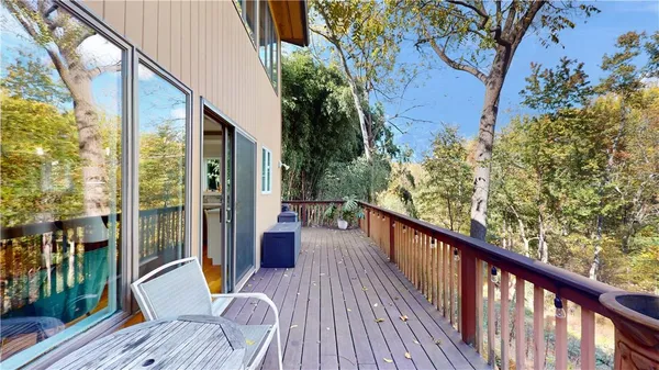 a balcony with wooden floor and furniture