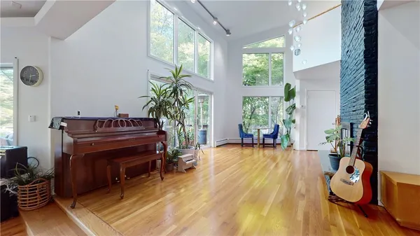 a living room with furniture a piano and a floor to ceiling window