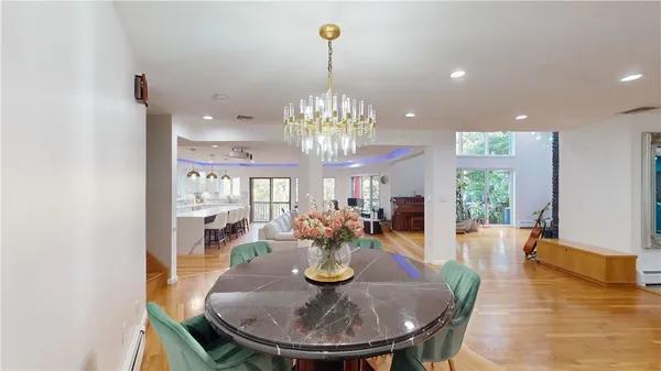 a view of a dining room with furniture a chandelier and wooden floor