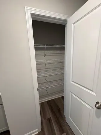 a view of walk in closet with empty racks