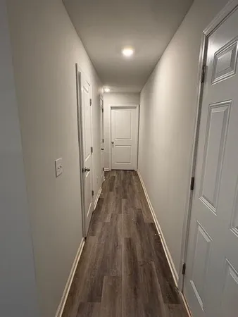 a view of a hallway with wooden floor