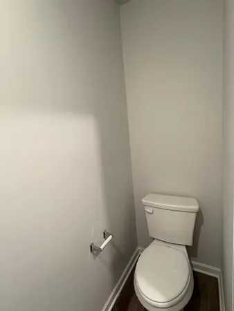 a white toilet sitting next to a white wall