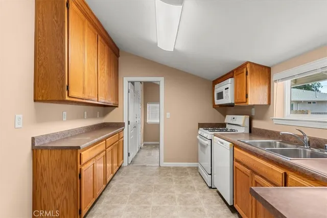 a kitchen with granite countertop a sink stove and cabinets