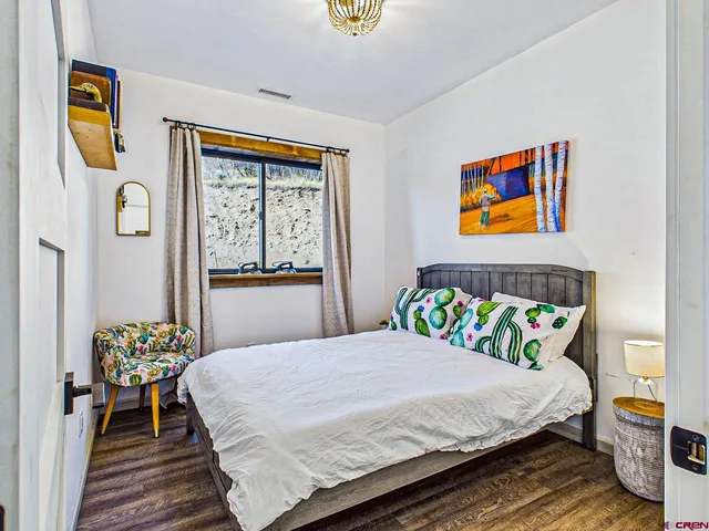 a bedroom with a bed and painting on the wall