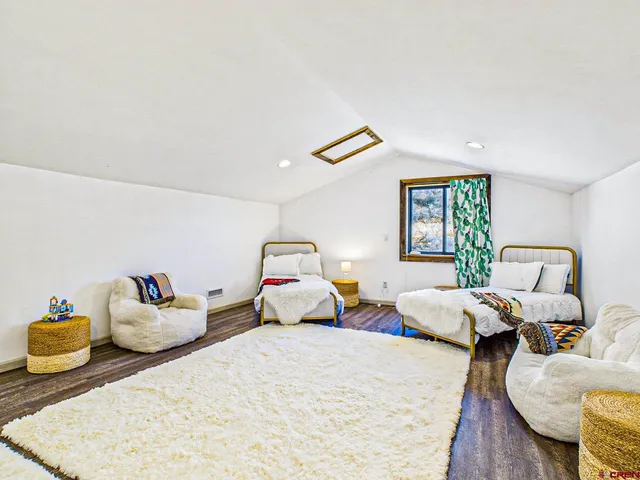 a bedroom with two beds and painting on the wall