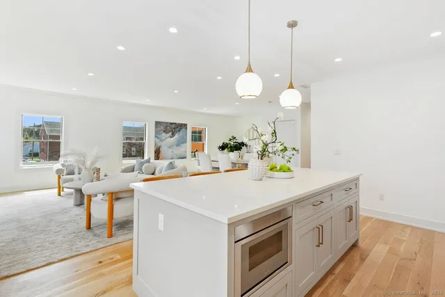 a kitchen that has a lot of white cabinets and wooden floor