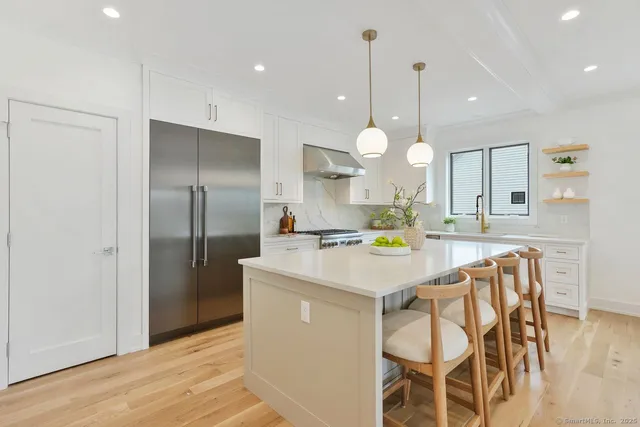 a kitchen with a dining table cabinets and stainless steel appliances