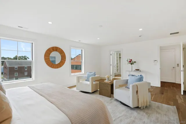 a bedroom with furniture and a large window