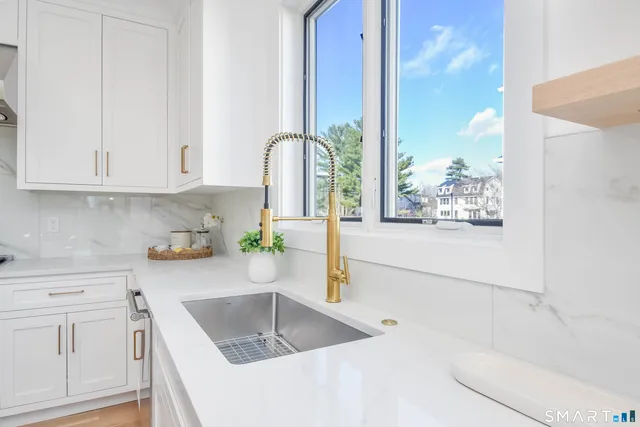 a kitchen with white cabinets and window