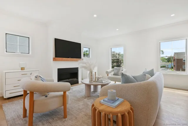 a living room with furniture a fireplace and a flat screen tv