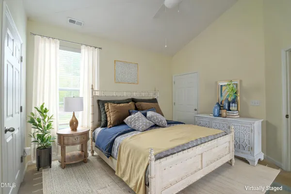 a bedroom with a large bed and a potted plant