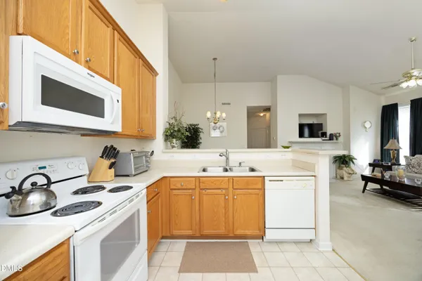 a kitchen with stainless steel appliances a sink a stove top oven a chimney a sink and cabinets