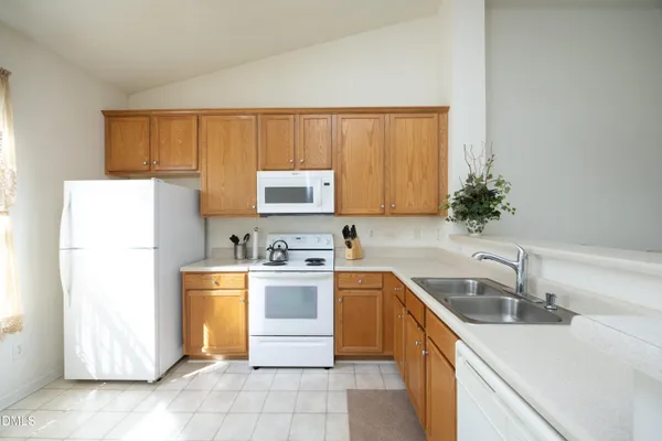 a kitchen with a sink a refrigerator and a stove top oven