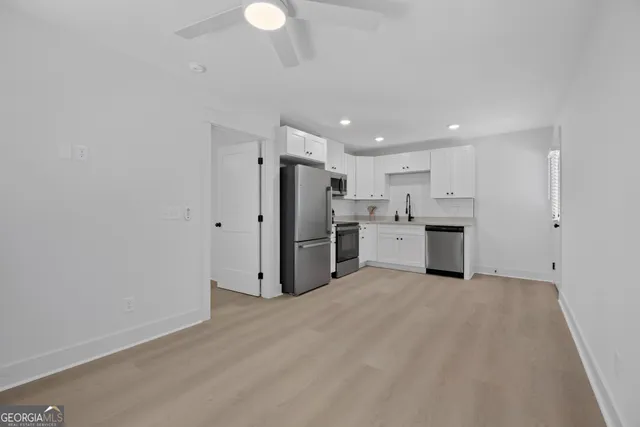 an empty room with windows and ceiling fan