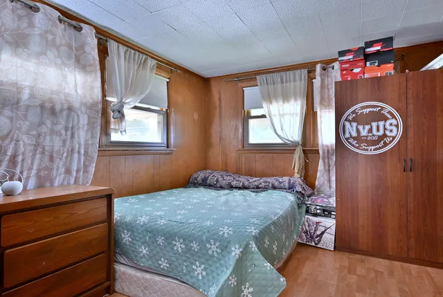 a bedroom with a bed a closet and a large mirror