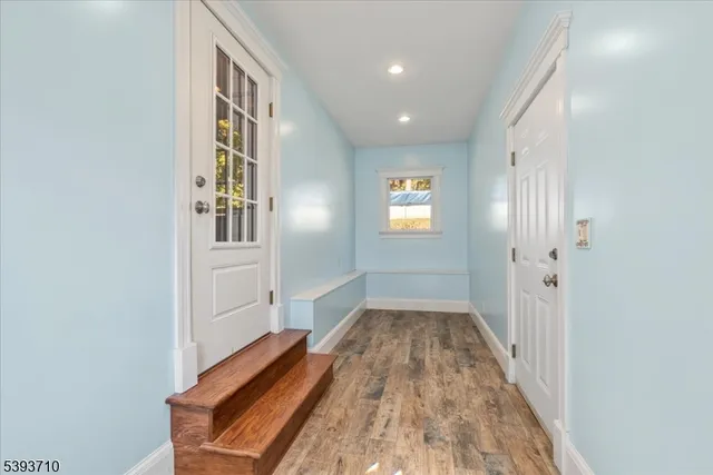 wooden floor with a window in a hall with an entryway