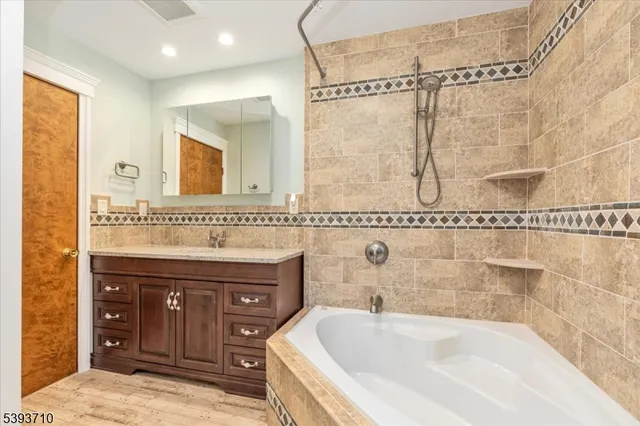 a bathroom with a tub sink and mirror
