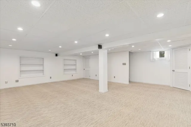 an empty room with a cabinet and mirrors