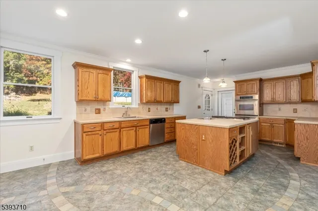 a large kitchen with stainless steel appliances granite countertop a stove sink and cabinets
