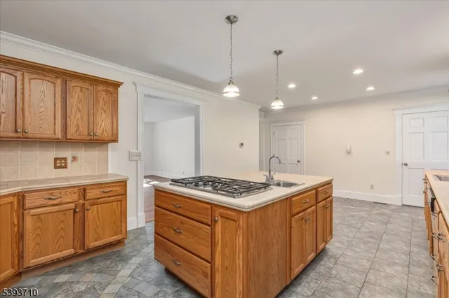a kitchen with a stove a sink a refrigerator and chairs
