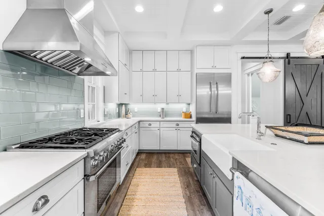 a kitchen with a stove a clock and wooden floor