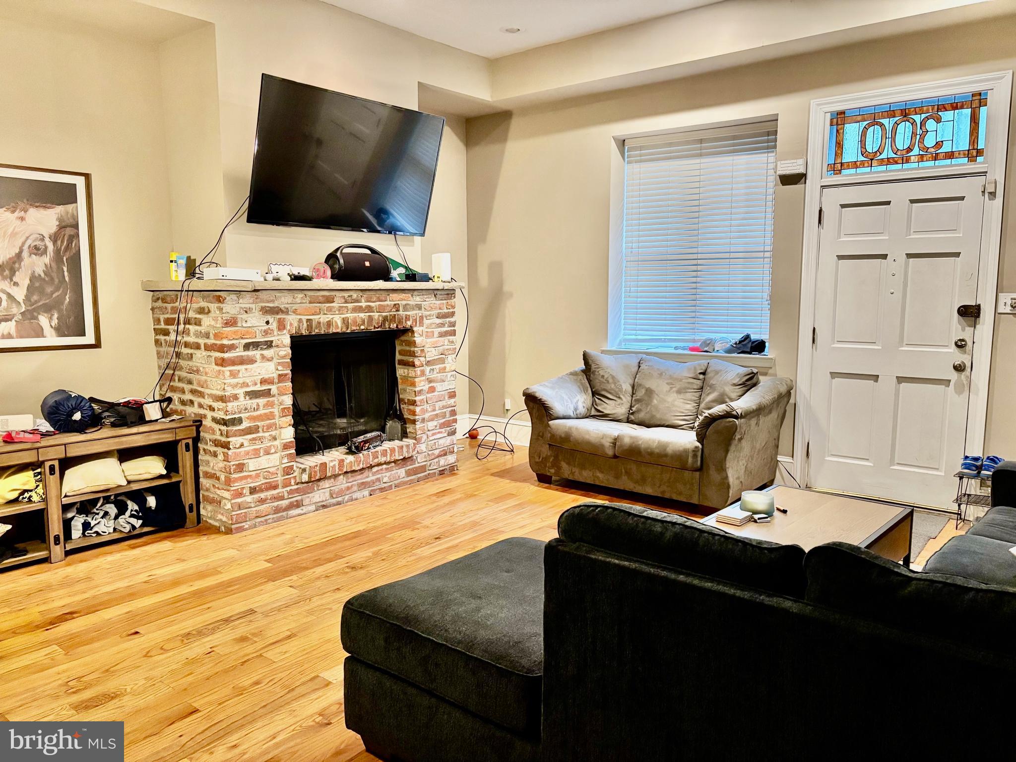 300 Lombard Street Philadelphia, PA 19147 - Photo 4 of 14 a living room with furniture a flat screen tv and a fireplace
