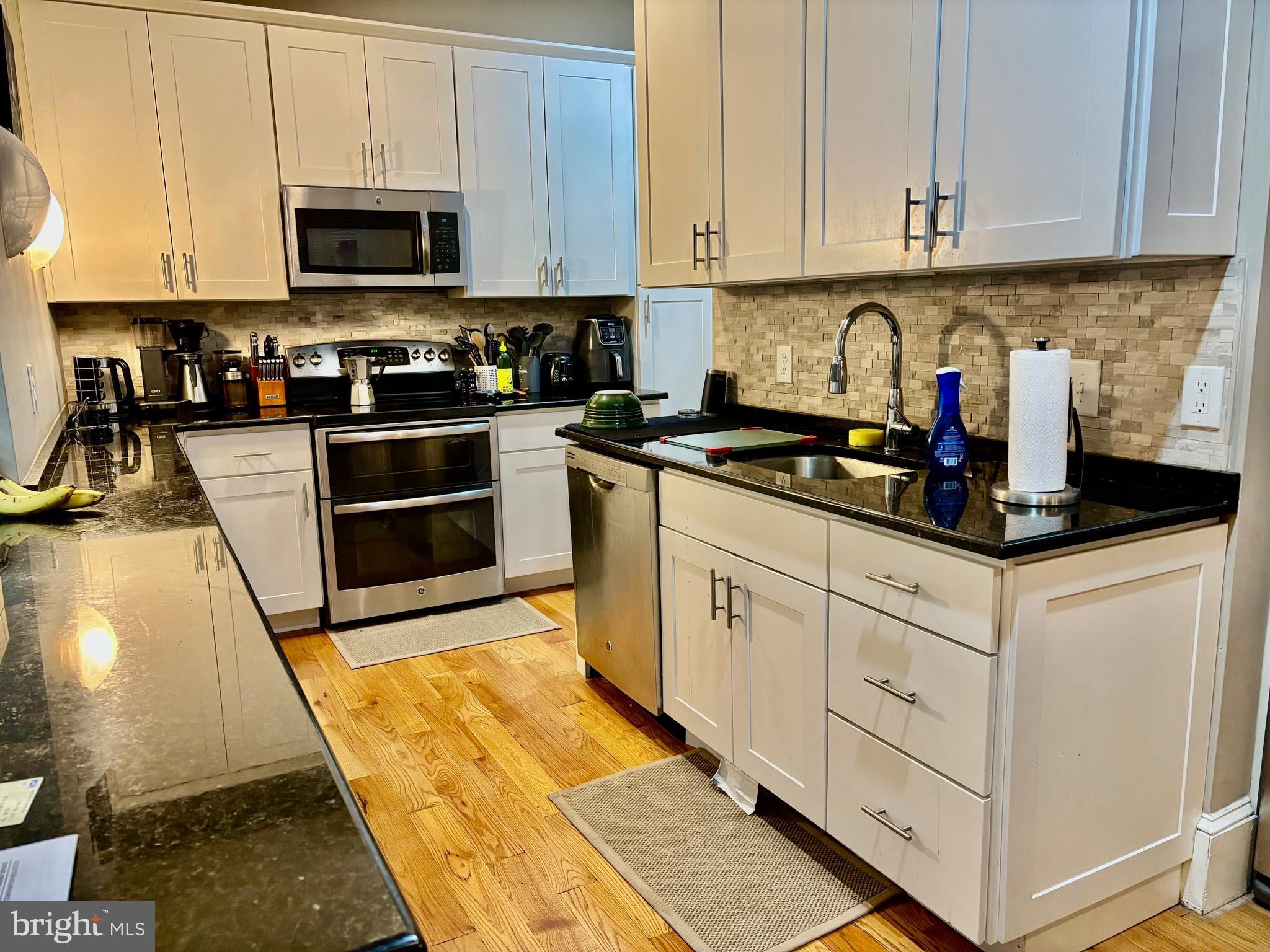 300 Lombard Street Philadelphia, PA 19147 - Photo 8 of 14 a kitchen with granite countertop a sink a stove and cabinets