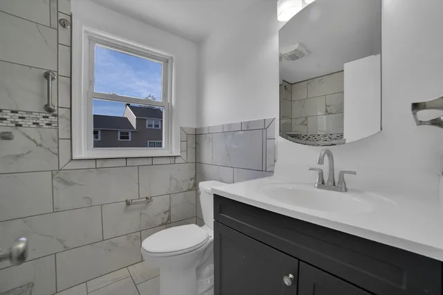 a bathroom with a sink a toilet and mirror