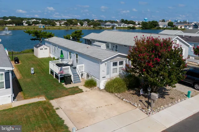 an aerial view of a house with a garden and lake view