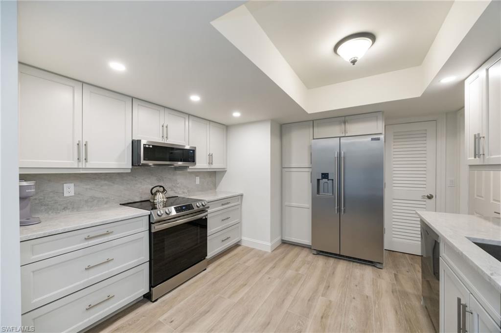 383 Harbour Drive, Unit 101 Naples, FL 34103 - Photo 4 of 30 Stainless appliances and stunning white cabinetry