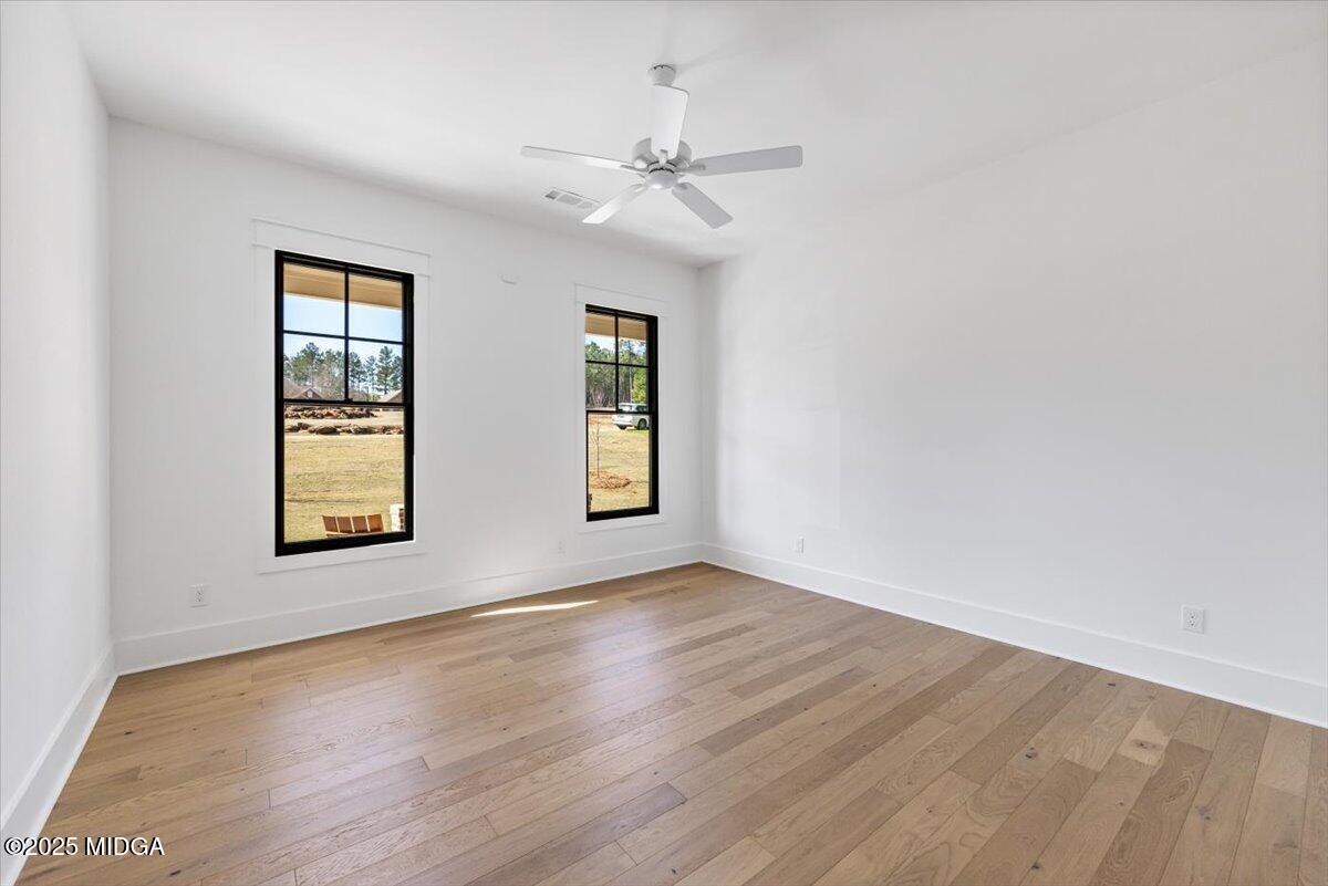 104 Piedmont Circle Forsyth, GA 31029 - Photo 20 of 42 an empty room with wooden floor chandelier fan and windows