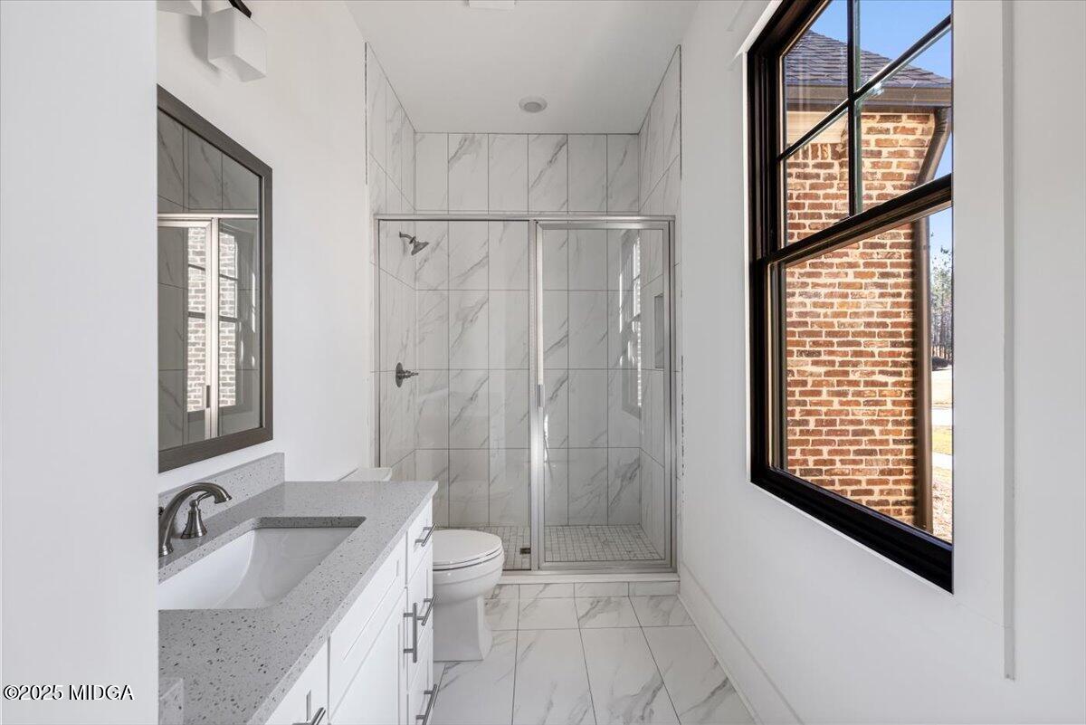 104 Piedmont Circle Forsyth, GA 31029 - Photo 22 of 42 a bathroom with a bathtub sink vanity mirror and a shower