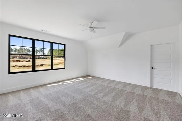 an empty room with windows and ceiling fan view