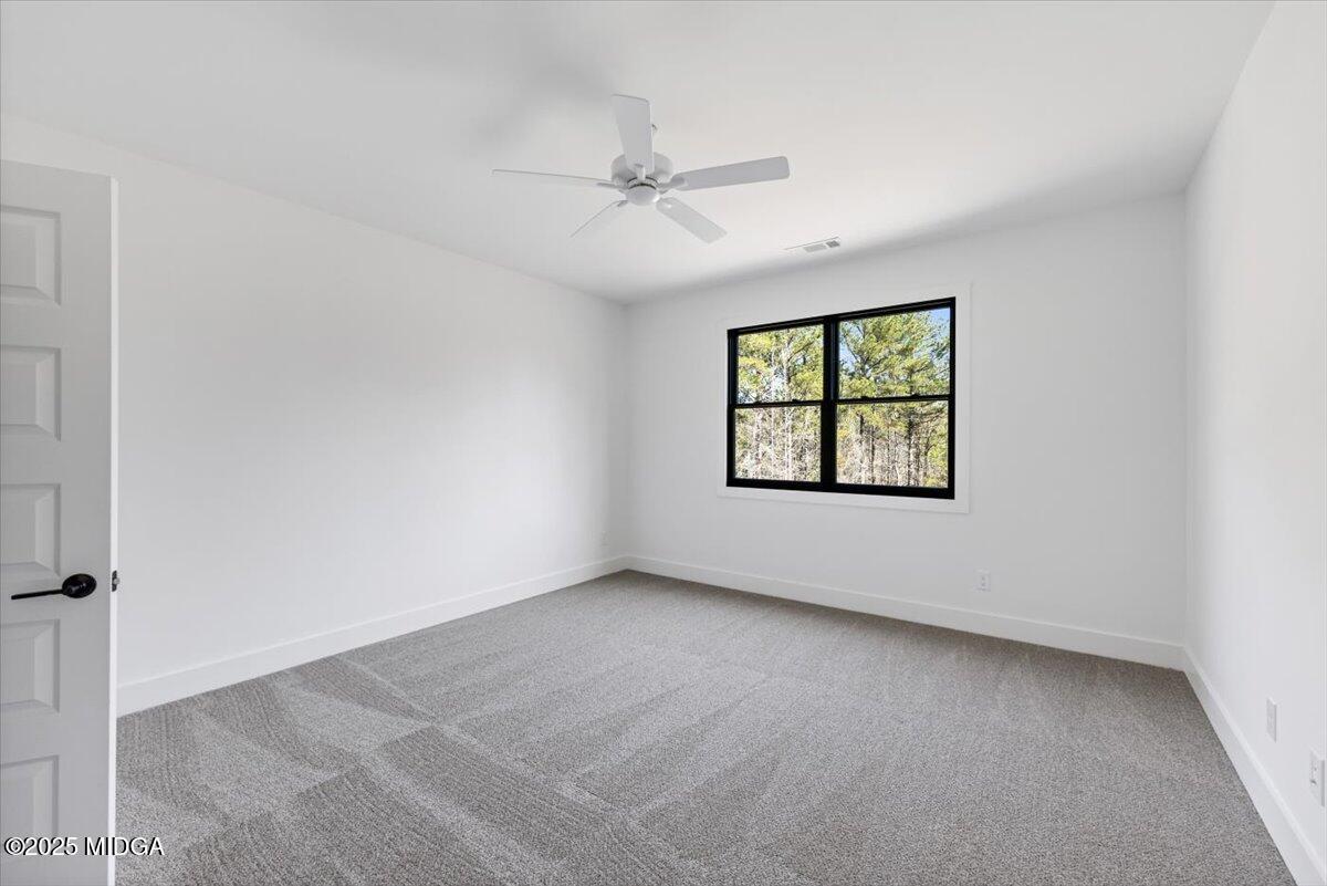 104 Piedmont Circle Forsyth, GA 31029 - Photo 29 of 42 an empty room with windows and ceiling fan view