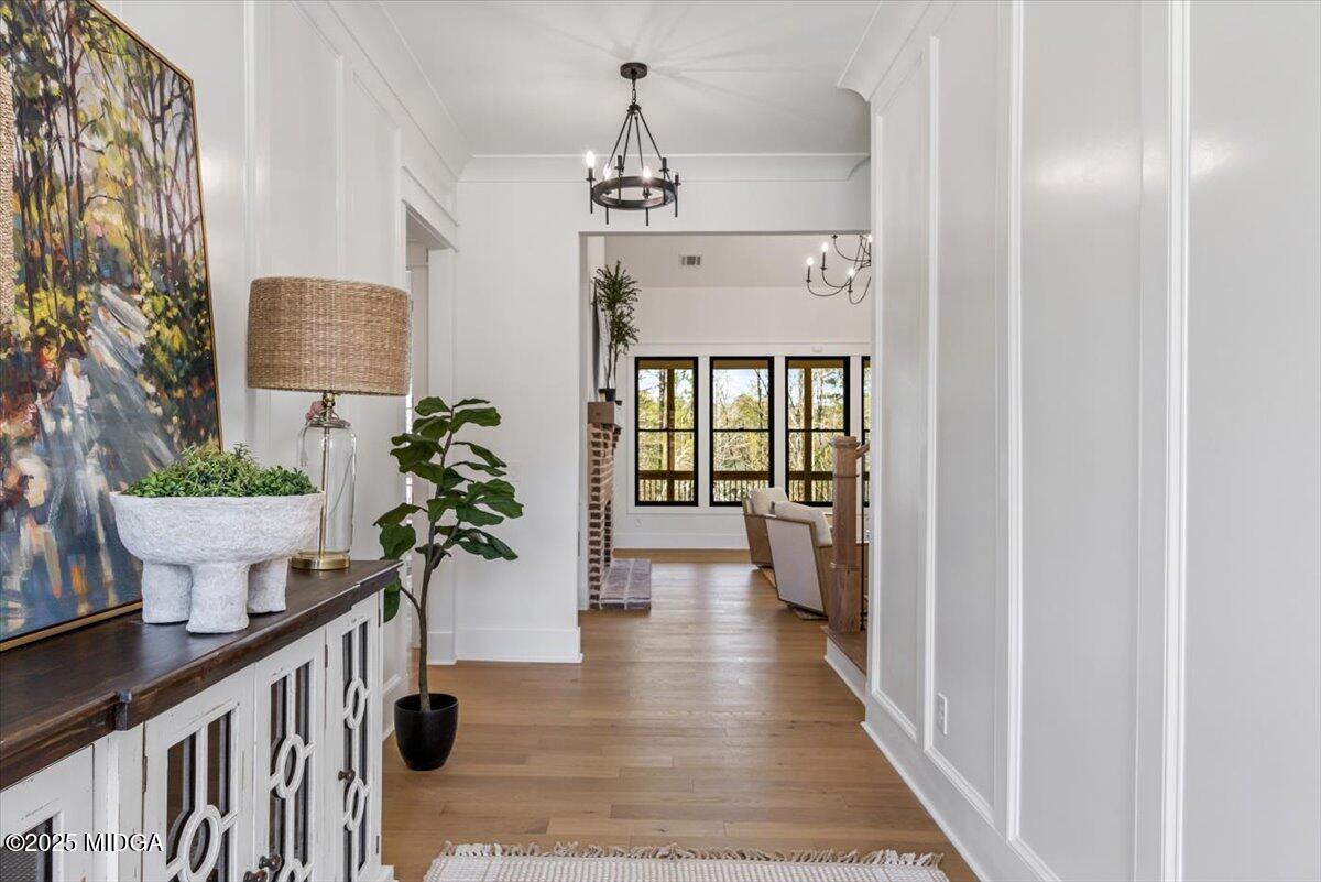 104 Piedmont Circle Forsyth, GA 31029 - Photo 4 of 42 a view of a hallway to a livingroom with wooden floor and a potted plant