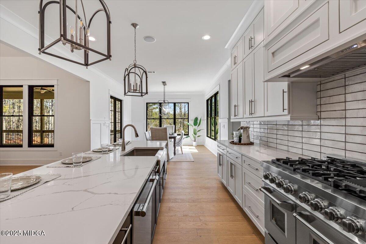 104 Piedmont Circle Forsyth, GA 31029 - Photo 9 of 42 a large kitchen with stainless steel appliances granite countertop a stove a chimney a sink and cabinets