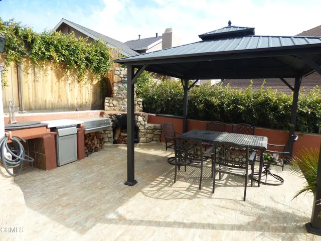 a view of a patio with table and chairs under an umbrella
