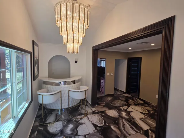 a living room with a large window and chairs